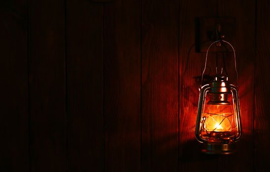 Cabin in the Woods title
    image. A picture of a glowing lantern on a wooden wall.
